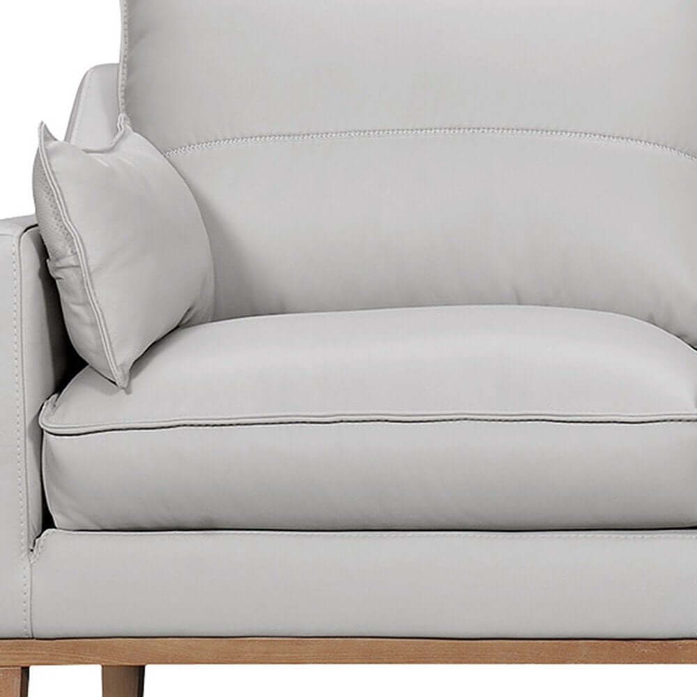 87" Gray Leather Sofa And Toss Pillows With Brown Legs close-up of soft leather cushion and pillow