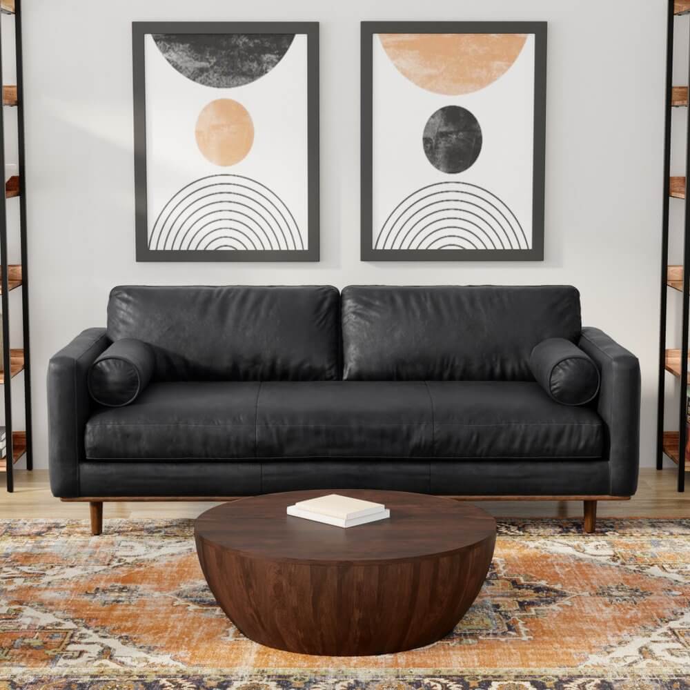 89" Black Leather Sofa With Brown Legs in stylish living room with modern decor.