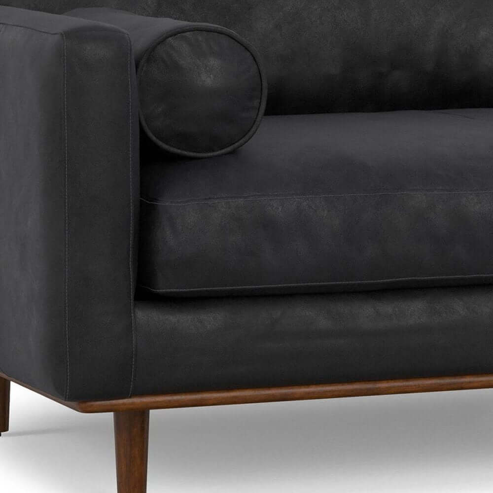 89" Black Leather Sofa With Brown Legs close-up view of arm and cushion detailing