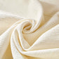 Close-up of soft, textured cream fabric, perfect for upholstery in a cozy sectional sofa.