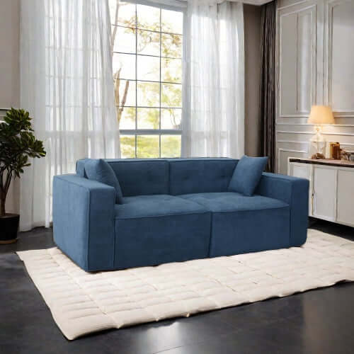 Modern low profile box arm memory foam sofa in blue, designed for comfort and style, placed in a bright living room setting.