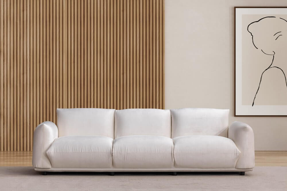 98" White Velvet Sofa in a modern living room setting with wood panel wall and framed artwork.