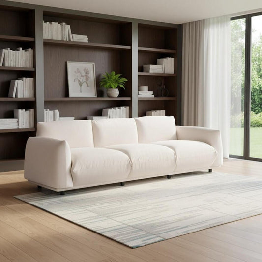 98" White Velvet Sofa in a modern living room with bookshelves and natural light.