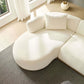 Rounded L-shaped chaise sofa sectional in cream color with plush cushion, enhancing modern living room decor.