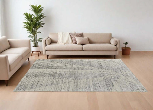 9' X 13' Ivory and Gray Abstract Hand Knotted Worn Faded Area Rug in a modern living room setting.