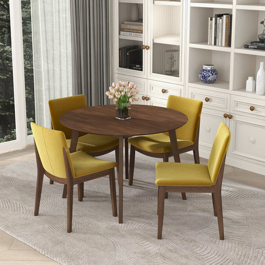 The Alina MCM Round Walnut Wood Dining Table 43 by Ashcroft Furniture, available in 2 colors, is paired with four yellow upholstered chairs, set on a patterned rug in a room with built-in shelves and gray curtains.