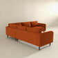 The Amber MCM Corner Sectional Sofa 103 by Ashcroft Furniture, shown in burnt orange with clean lines and wooden legs, brings modern style and premium craftsmanship to a minimalist room with light walls and flooring.