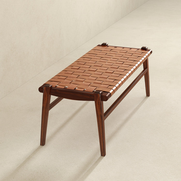 The Cody MCM Strapped Genuine Leather Bench 44 by Ashcroft Furniture features a tan woven genuine leather seat and four angled wooden legs, offering a minimalist, modern style perfect for any space.