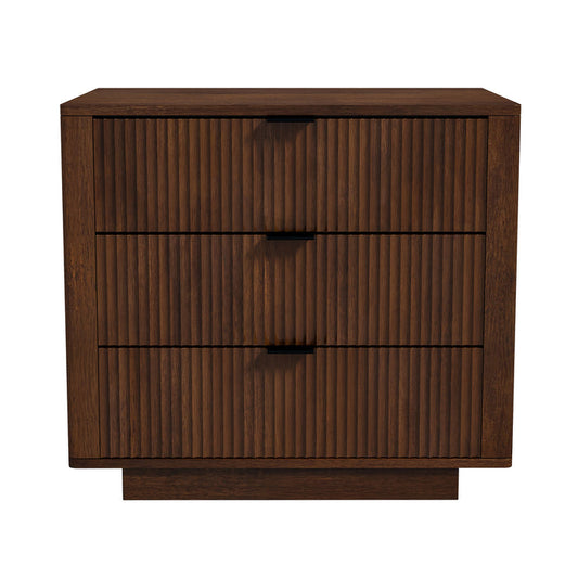 The Ashcroft Furniture Lola Styled Solid Wood Walnut Nightstand 31 features three drawers, a rich walnut finish, vertical grooved fronts, minimalist black handles, and a sleek Mid-Century Modern inspired rectangular design.