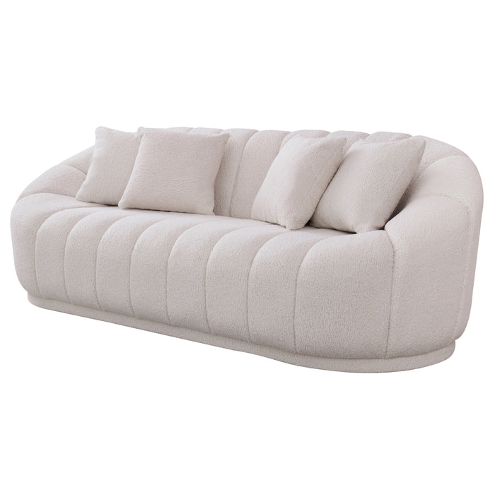 The Ashcroft Furniture Maximilian Japandi Channel Tufted Boucle Sofa 86” features a modern, plush white design with curved edges, vertical tufting, four matching cushions, and is shown against a plain white background.