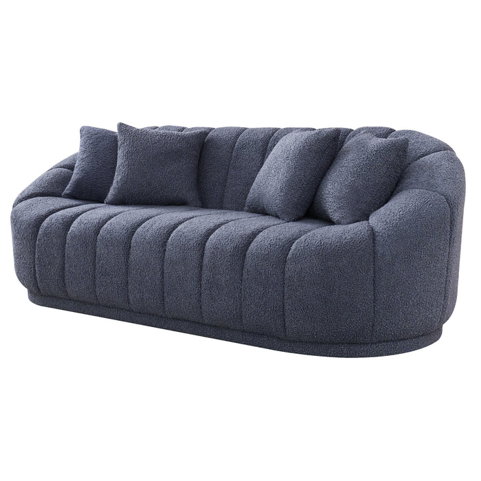 The Ashcroft Furniture Maximilian Japandi Channel Tufted Boucle Sofa 86”, in modern dark gray with a rounded back and three matching cushions, features channel tufted upholstery and is shown against a white background.