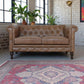 Buffalo Leather Chesterfield Loveseat 59" – Tufted Brown Leather Sofa with Rolled Arms in a stylish living room.