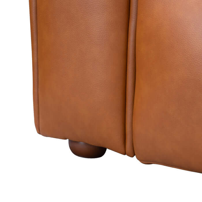 Close-up of cognac PU leather upholstery on Clark Tufted Chaise Sofa Sectional highlighting texture and rounded feet.