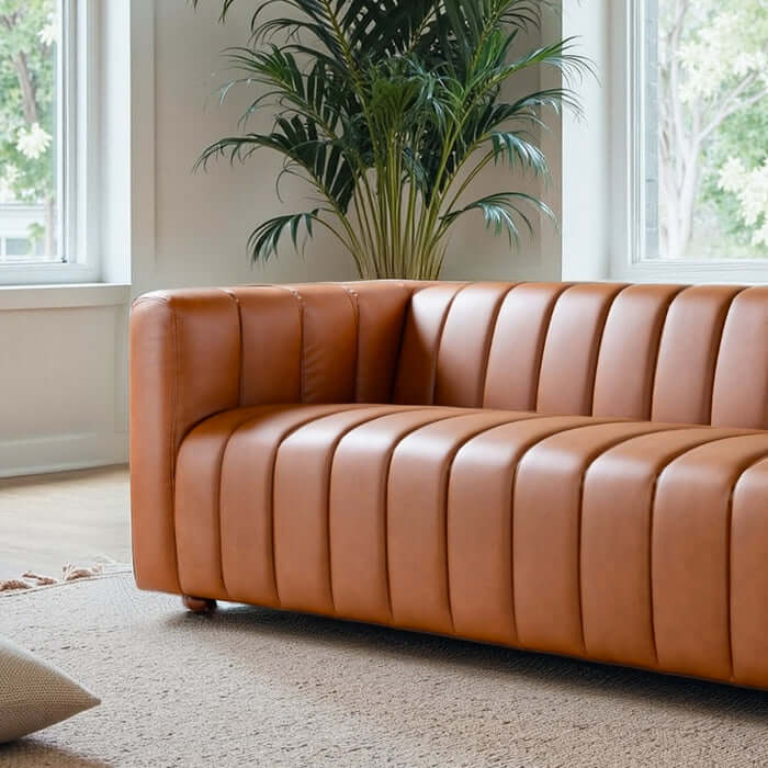 Elrosa Channel Tufted Cognac Faux Leather Sofa with channel tufting in modern living space.