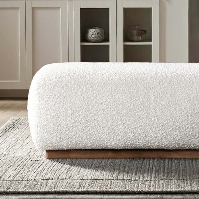Kelvin Ivory Boucle Ottoman Bench 47” with soft textured upholstery and wooden base in a modern living space.