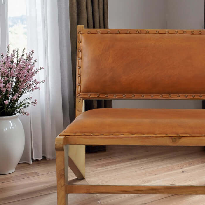 Talon solid wood lounge chair with tan leather upholstery, featuring a sleek design and accentuated by floral decor.