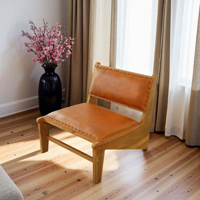 Talon Solid Wood Tan Leather Armless Lounge Chair in a stylish living room with floral decor.