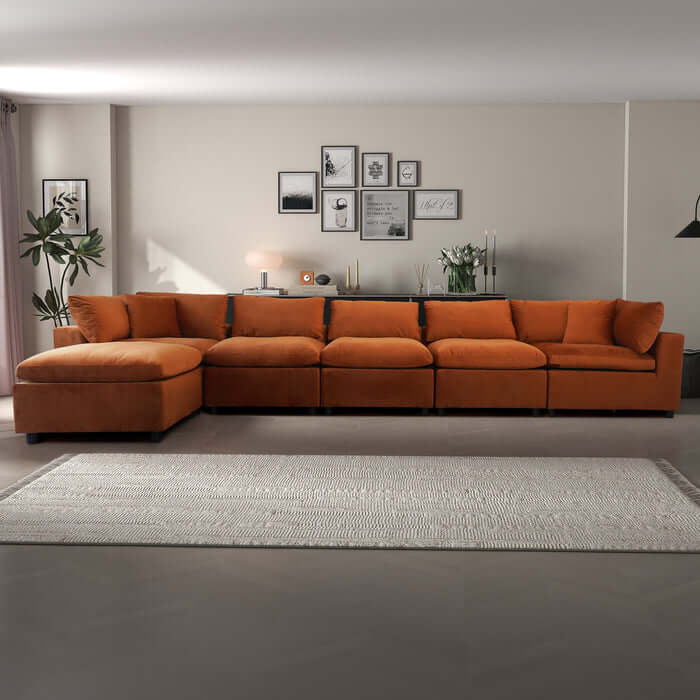 Hayward Velvet Modular Sectional Sofa in orange, showcasing plush upholstery and customizable seating arrangement.