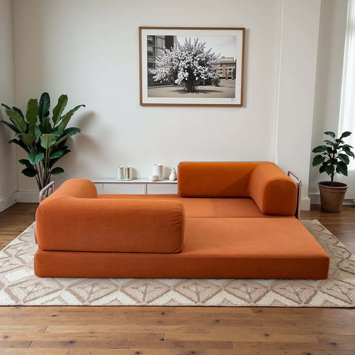 Estelle Modern Orange Corduroy Convertible Sofa Daybed in stylish living room setting with plants.
