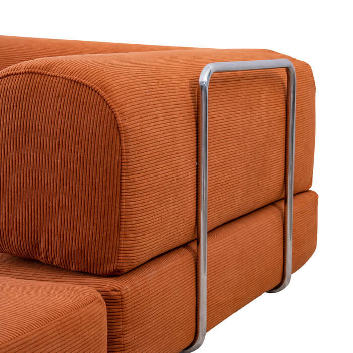 Close-up of Estelle orange corduroy sofa armrest with sleek metal accent, showcasing modern design.