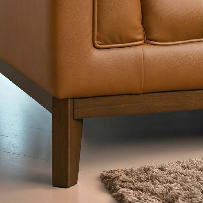 Close-up of Melissa MCM Vegan Leather Sofa corner with wood legs and soft vegan leather upholstery.