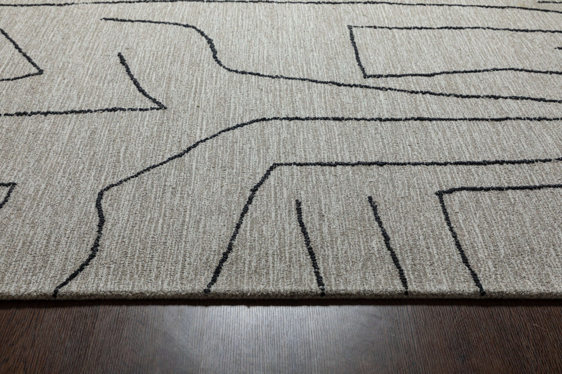 Close-up of Abbey Valetta handwoven wool area rug featuring abstract black lines on a neutral background.