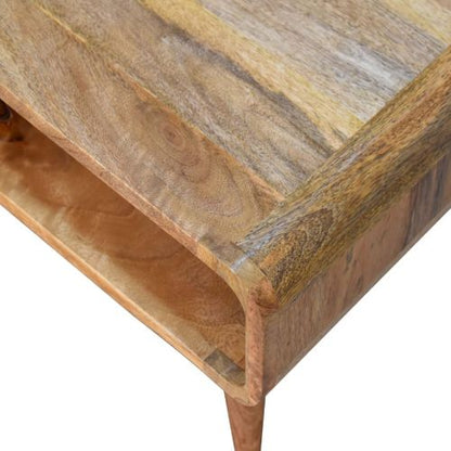 Close-up of Artisan Furniture’s MCM Solid Mango Wood Coffee Table 26 shows its smooth, rounded edges, natural wood grain, and Warm Chestnut Finish. An open shelf is visible beneath the tabletop, highlighting its mid-century style.