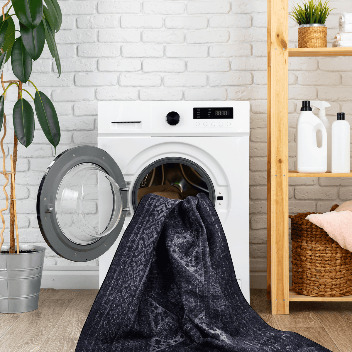 Black area rug being washed in a modern front-load washing machine, set in a stylish laundry room.