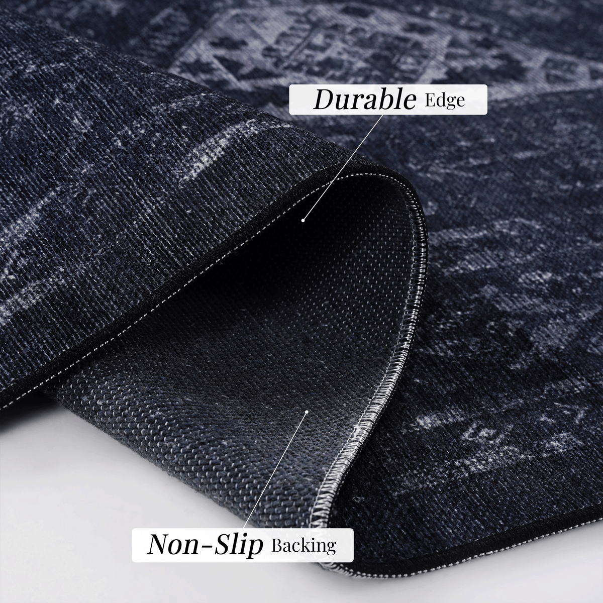 Close-up of black and gray area rug showing durable edge and non-slip backing features.