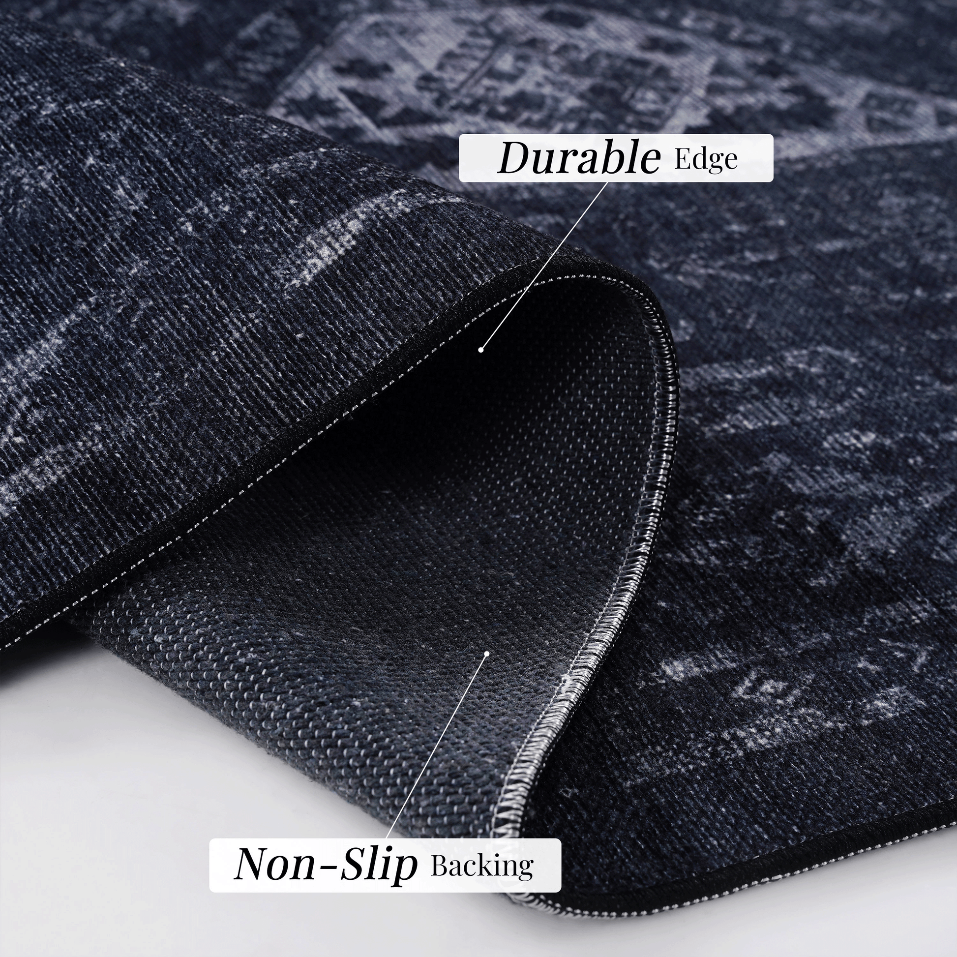 Close-up of black and gray area rug showing durable edge and non-slip backing features.