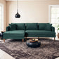 A modern living room with the Blake Velvet Upholstered L-Shape Chaise Sofa Sectional 107 by Ashcroft Furniture, a black round coffee table with fruit bowl, patterned rug, black pendant light, and large windows letting in natural light.