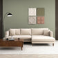 A modern living room with the Ashcroft Furniture Blake Velvet Upholstered L-Shape Chaise Sofa Sectional 107, a wooden coffee table, black floor lamp, four textured wall art panels on a green wall, light rug, and minimalistic decor for modern elegance.