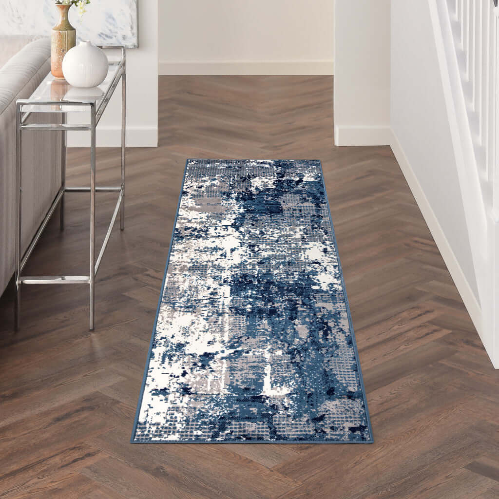 Blue abstract power-loom runner rug showcasing modern design in a hallway with wood flooring.