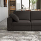 A modern living room features the Ashcroft Furniture Cecilia Dark Gray Modular Chaise Sofa Sectional 121 with a reversible chaise, neutral area rug, built-in shelving, large window, and a dining area overlooking city views.
