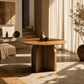 Delmon Dark Walnut Round Dining Table 47" in a warm, modern dining space with natural light and decorative elements.