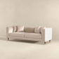 The Ashcroft Furniture Edward MCM Elegant Tufted Velvet Sofa 90 in beige, with four matching cushions, is showcased in a minimalist room featuring light-colored walls and flooring.