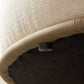 Close-up of the underside of a chaise sofa with a soft cream top and sleek black base, showcasing the design details.