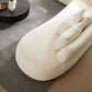 Cream rounded L-shaped chaise sofa with plush pillows, showcased in a modern living room setting.