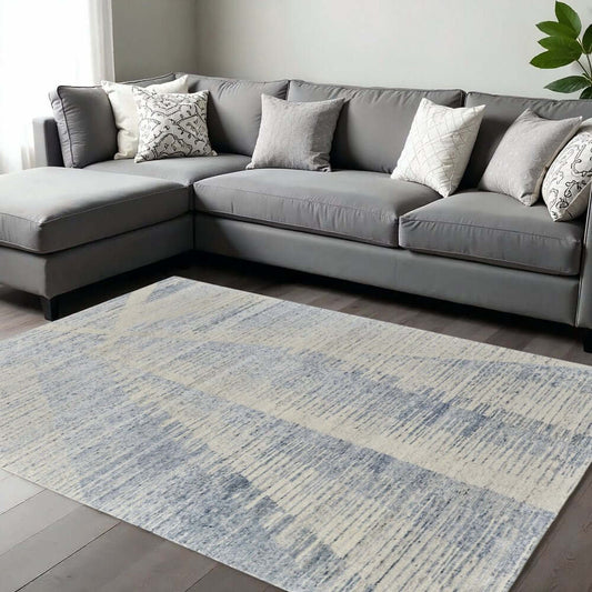 Ivory Blue And Silver Abstract Hand Knotted Distressed Area Rug | 9' x 13' displayed in a modern living room setting.