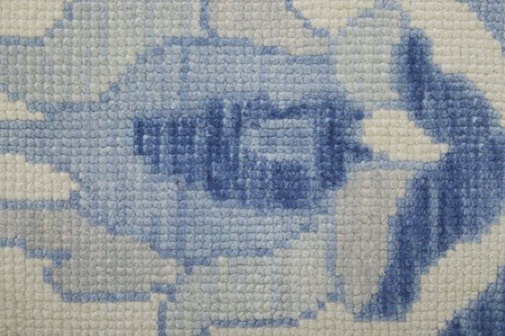 Close-up texture of Ivory and Blue Wool Floral Hand Knotted Area Rug With Fringe Area Rug | 9' x 13' in blue and ivory.