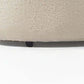 Close-up view of the base of an ivory boucle curved modular sectional sofa showcasing texture and design details.