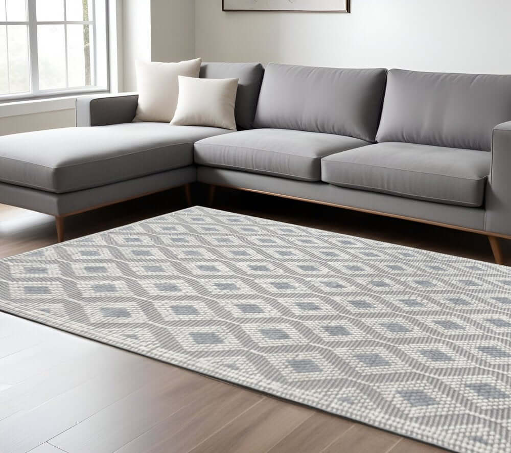 Ivory Gray Diamond Trellis Modern Area Rug | 9' x 13' placed in a contemporary living room with a gray sectional sofa.
