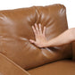 MCM Brown Faux Leather Armchair – Modern Upholstered Accent Chair with a hand resting on its plush cushion.