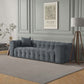 A modern living room featuring the Ashcroft Furniture Eden Modern Boucle Bubble Sofa 90, a floor lamp with a gray shade, a framed Picasso print, and a small plant on a side table. Decorative paneling on the light gray walls adds glamour.