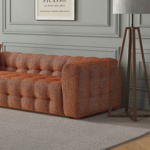 A modern living room showcases the Ashcroft Furniture Eden Modern Boucle Bubble Sofa 90 on a gray rug, beside a tall tripod lamp with a gray shade, all set against decorative gray wall paneling and glam design elements.