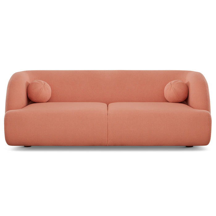 The Anna Boucle Fabric Upholstered Sofa 87 by Ashcroft Furniture features a modern, minimalist design in dusty pink with rounded edges, two matching round cushions, a low back, and a sleek silhouette for contemporary elegance.