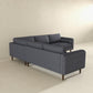 The Amber MCM Corner Sectional Sofa 103 in dark gray by Ashcroft Furniture, featuring wooden legs, is set in a bright minimalist room with light beige walls and floor, shown from the back and side.