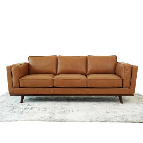 The Ashcroft Furniture Chase MCM Genuine Leather Sofa 91 is a modern three-seater with clean lines and wooden legs, shown on a light rug against a white backdrop, reflecting the elegance of luxury furniture.