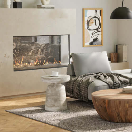 Modern living room featuring a cozy fireplace, gray sofa, stone accent table, and wooden coffee table.