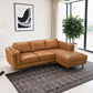 A modern living room featuring the Ashcroft Furniture Chase MCM Tan Leather Chaise Sofa Sectional 92 on a patterned gray rug, with a large potted plant, abstract black-and-white wall art, and floor-to-ceiling windows with light curtains.